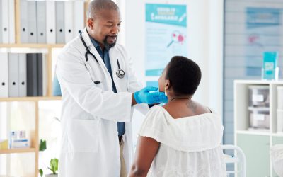 Mature african american doctor checking the throat of a patient. Patient in a checkup with her doct.
