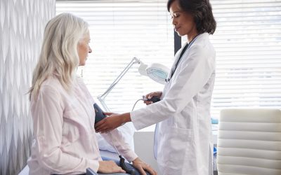 Woman Patient Having Blood Pressure Taken By Female Doctor In Office